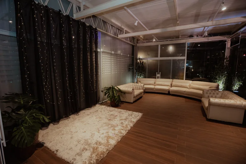 Área de lounge com sofá curvo elegante e iluminação âmbar